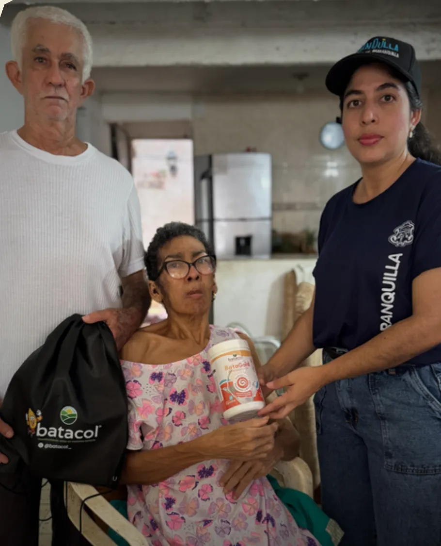 Pareja de adultos mayores recibe BataGold junto a una profesional del proyecto con la Alcaldía de Barranquilla